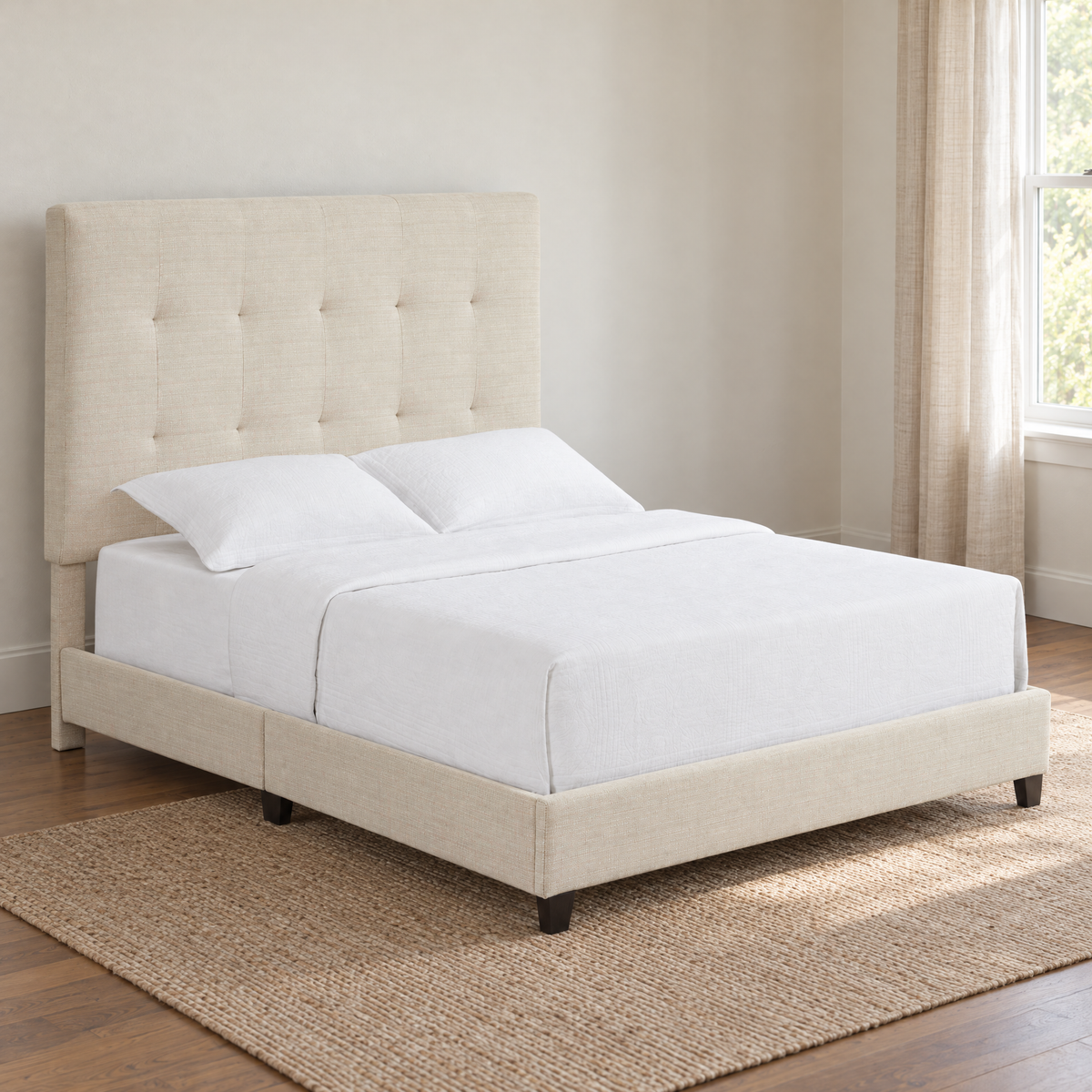 Beige upholstered queen bed with a tufted headboard in a naturally lit bedroom