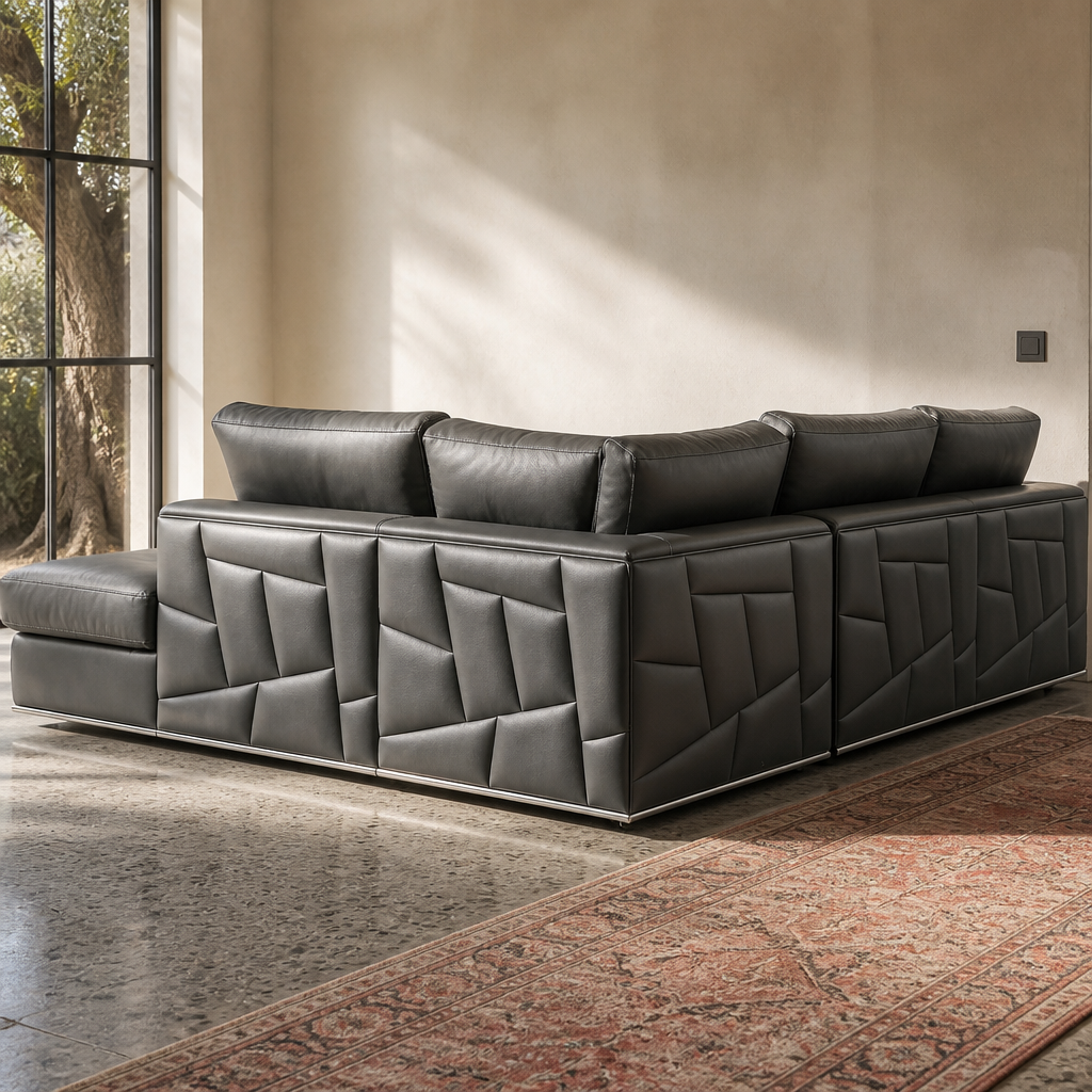 Rear view of the Surton sectional showing the faceted geometric leather panelling in raking daylight