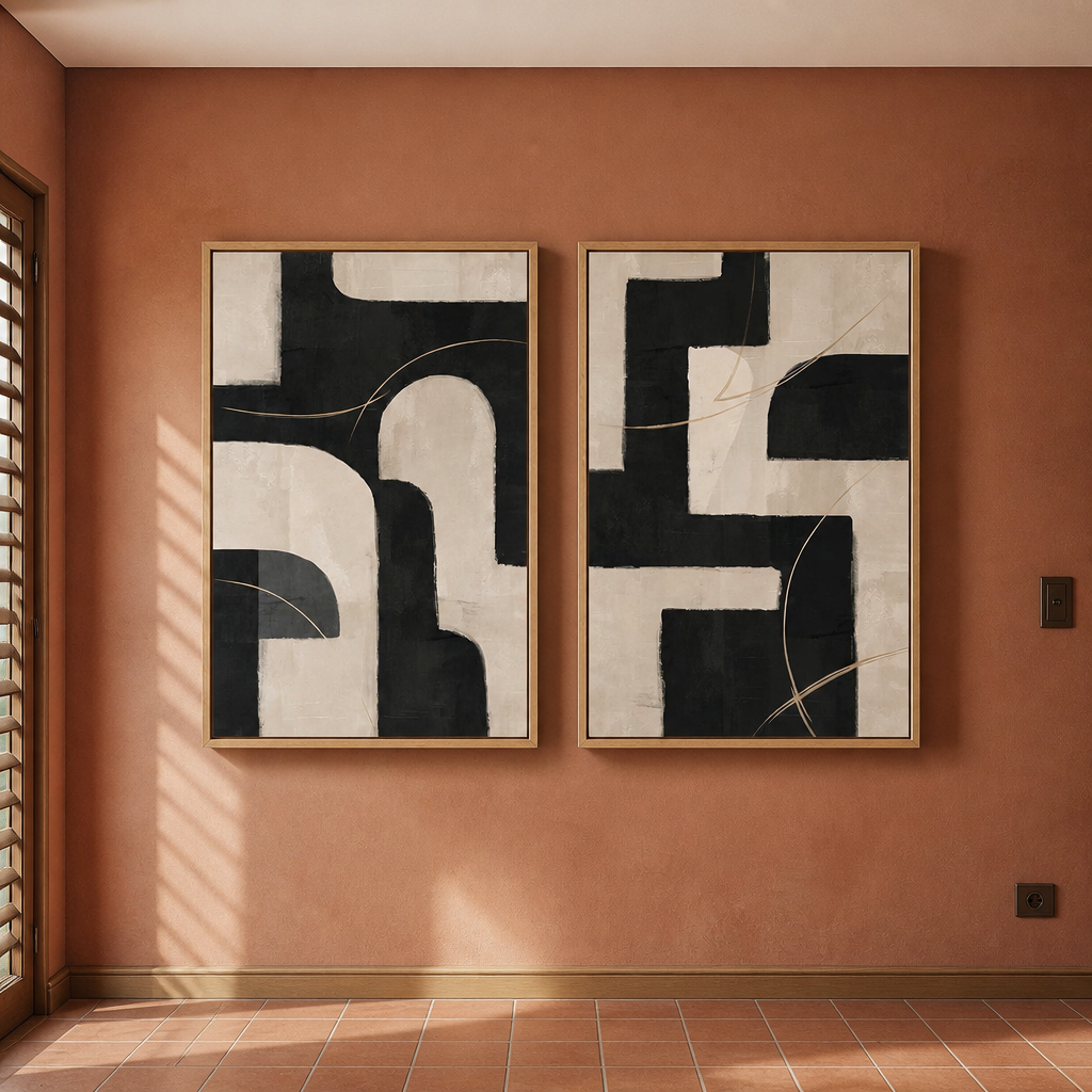 Pair of 24 by 36 inch framed black and beige abstract art prints on a clay plaster wall