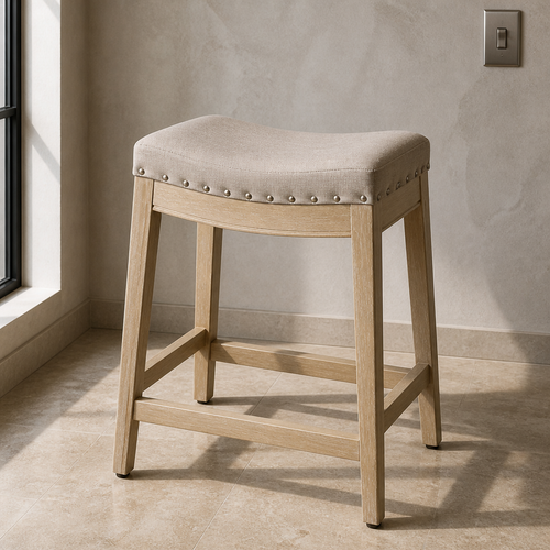 Backless linen saddle counter stool, three-quarter product portrait against bone plaster