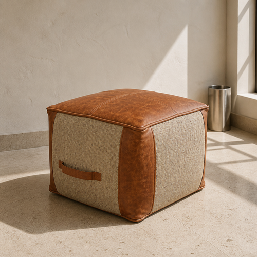 Square jute and tan leather pouf ottoman, close portrait on a travertine floor against a bone plaster wall