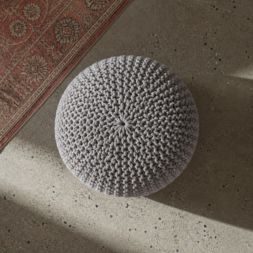 Overhead view of the crown rosette of the grey knitted pouf ottoman