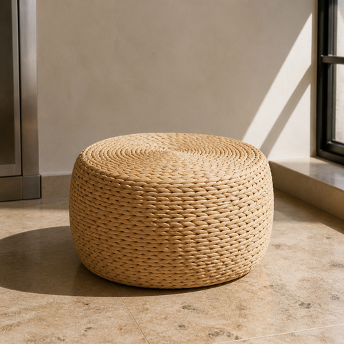 Round handwoven natural straw ottoman, close portrait in a travertine interior