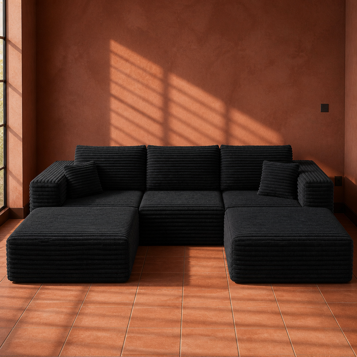 Black wide-wale corduroy U-shaped modular sectional sofa, 108 inches long, on a terracotta tile floor