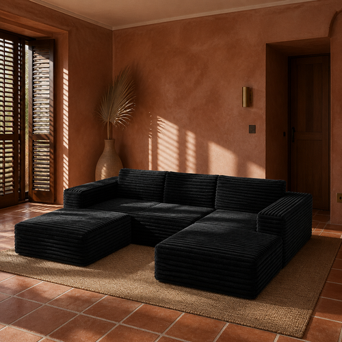 Black corduroy U-shaped sectional in a rust clay plaster room with terracotta tile and timber shutters
