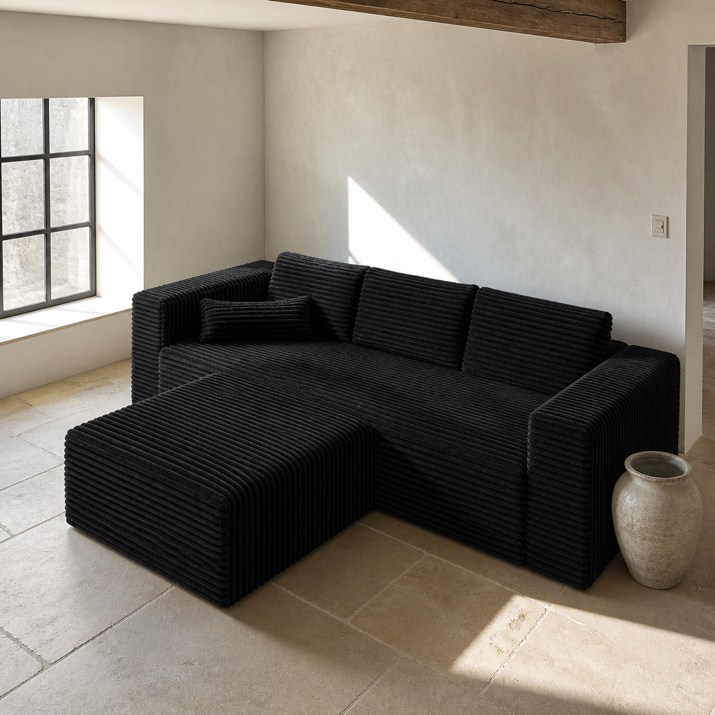 High three quarter view of the black corduroy sofa showing the left facing chaise return