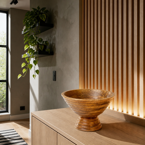 Turned mango wood footed bowl on an oak console against a backlit white oak slat wall