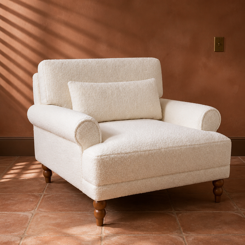 Boucle white accent chair with rolled arms and turned walnut Roman column legs in a rust clay plaster room