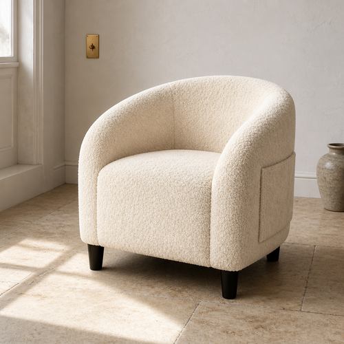 Cream boucle barrel accent chair, close front three-quarter portrait in a chalk and limestone room
