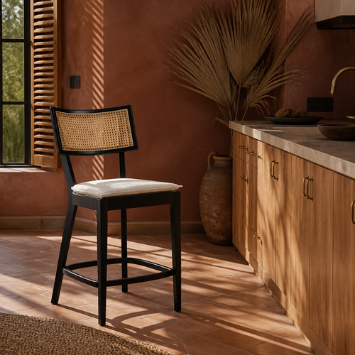 Caledonia cane back bar stool at a kitchen counter in a terracotta plaster room