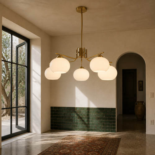 Brass and opal glass chandelier hanging in a Mediterranean room with zellige tile and concrete floor