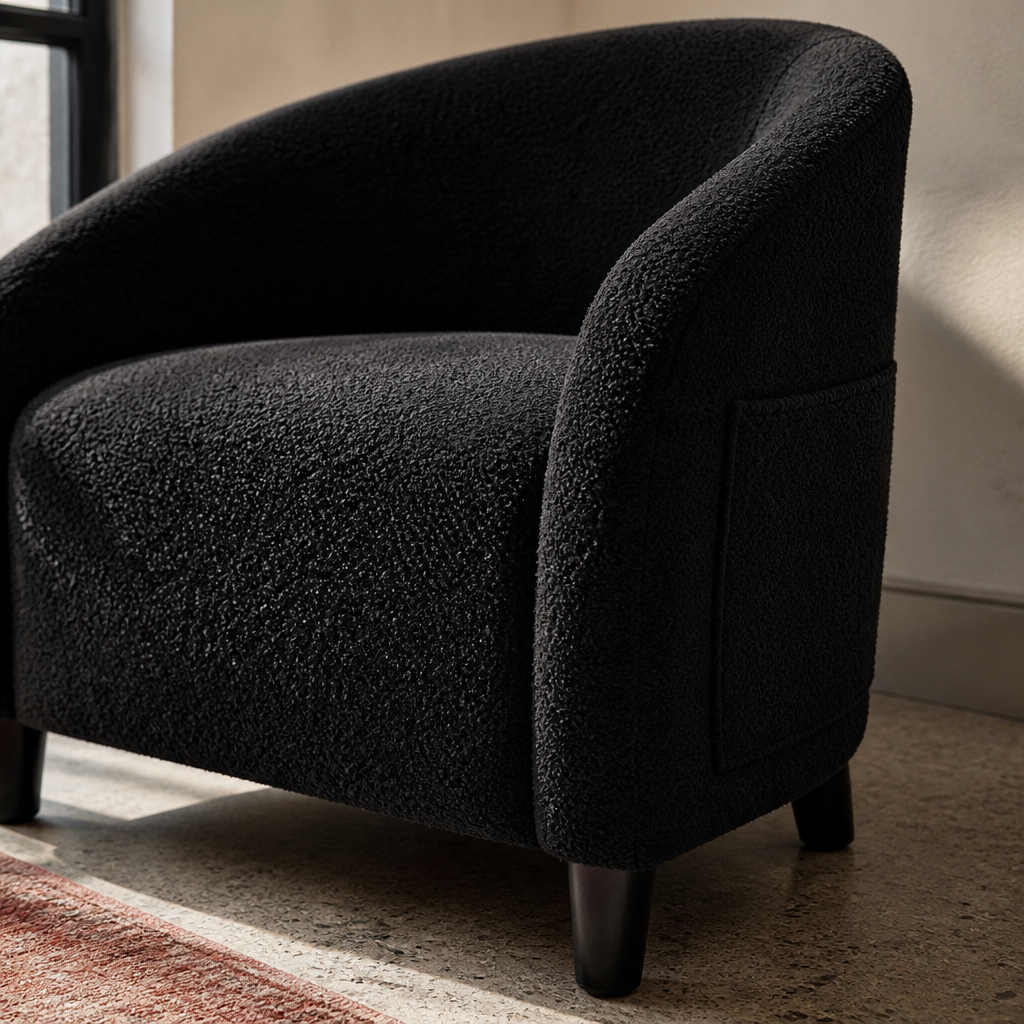 Close detail of the black boucle pile and tapered black leg of the accent chair