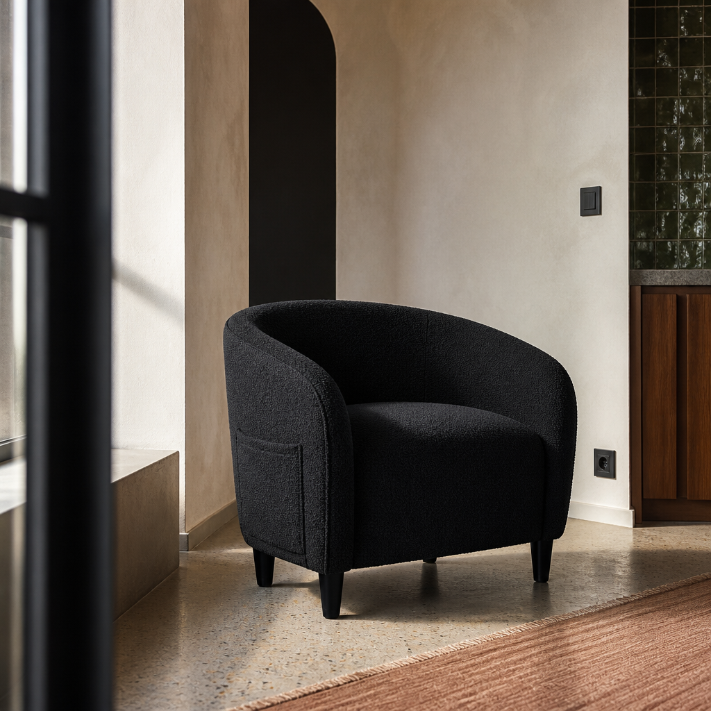 Black boucle barrel accent chair styled against an arched opening, framed past a window edge