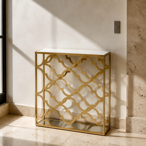 Narrow gold quatrefoil console table with white marble top, close portrait against travertine