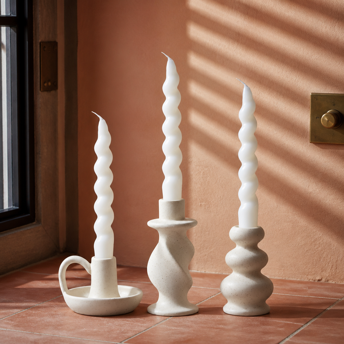 Set of three cream white speckled ceramic taper candle holders with twisted candles