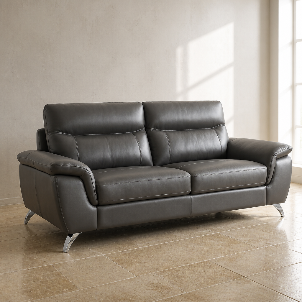 Chicago top grain leather sofa in dark charcoal grey with polished chrome cantilever legs, close product view against a chalk white lime wash wall and limestone flag floor