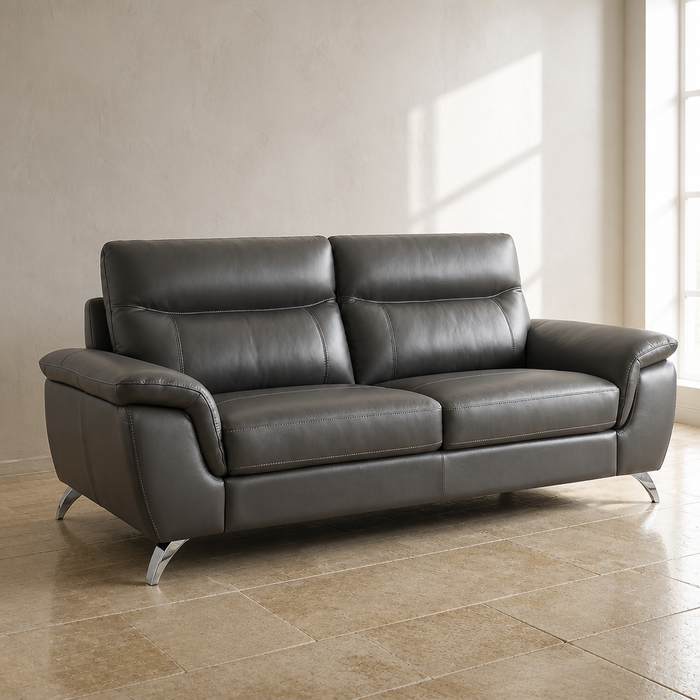 Chicago top grain leather sofa in dark charcoal grey with polished chrome cantilever legs, close product view against a chalk white lime wash wall and limestone flag floor