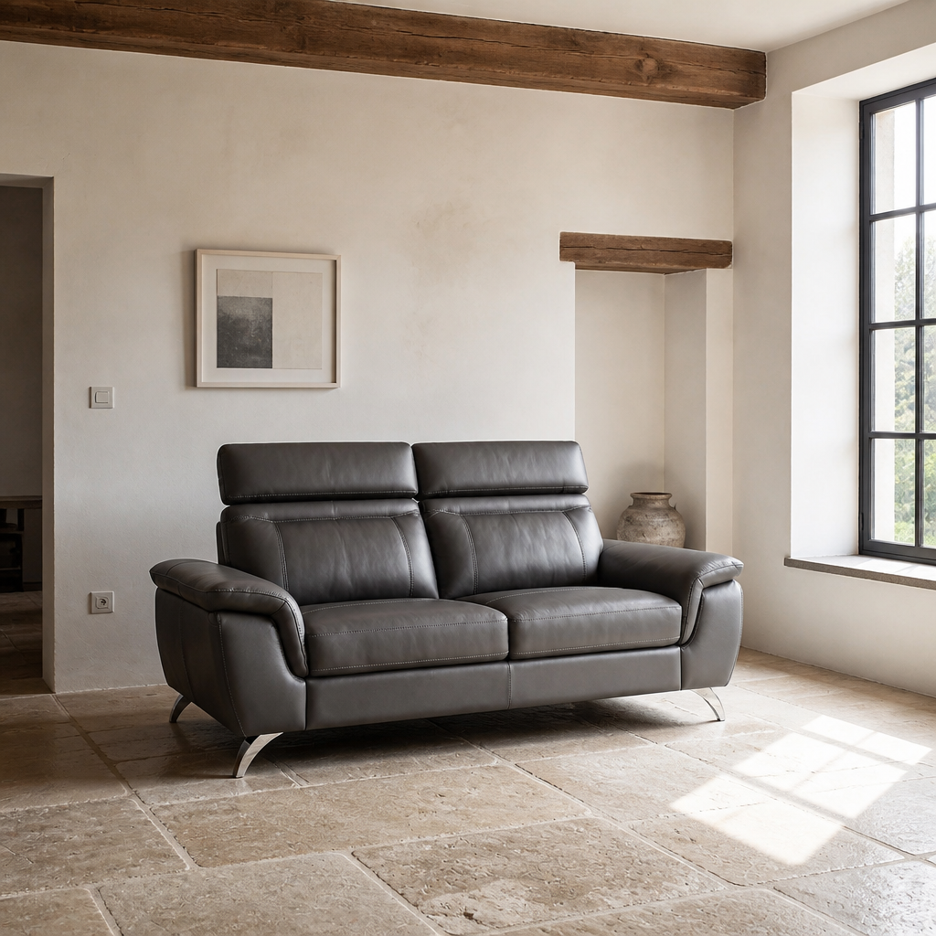 Chicago charcoal leather sofa seen across a chalk and limestone room with an exposed timber beam and a stoneware vessel