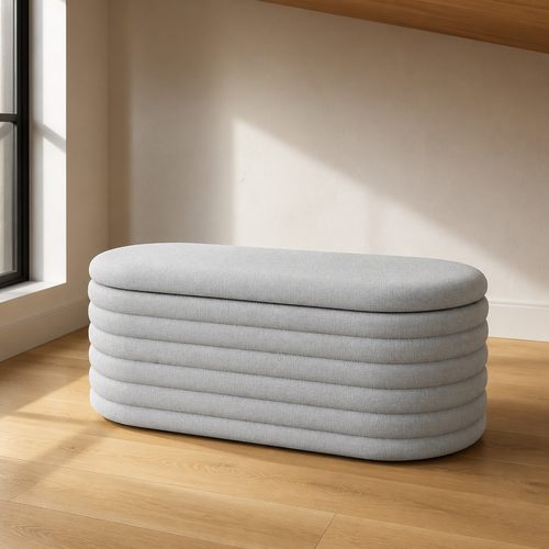 Light grey channel tufted oval chenille storage bench, 40 inches wide, shown close against a warm white plaster wall on a white oak floor