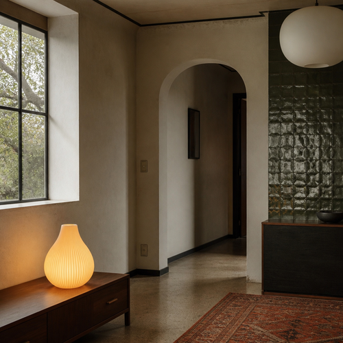 Ribbed white ceramic lamp in a Mediterranean room with lime plaster walls and zellige tile