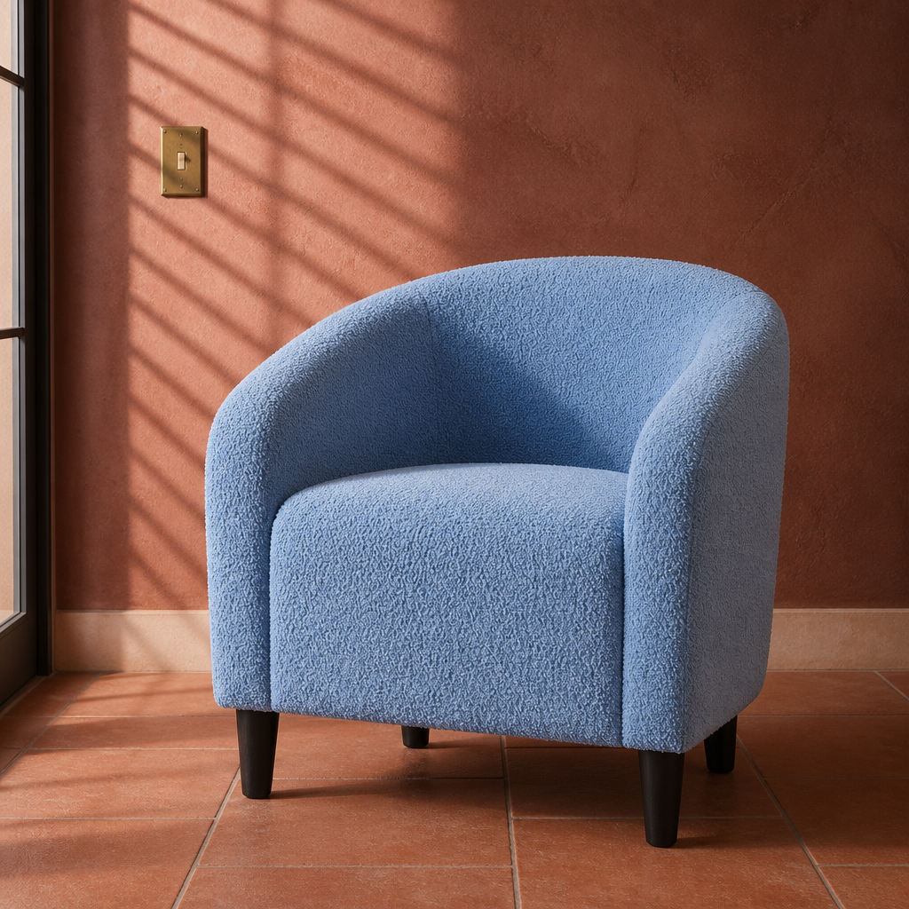 Blue boucle barrel accent chair, close product portrait in a terracotta plaster room