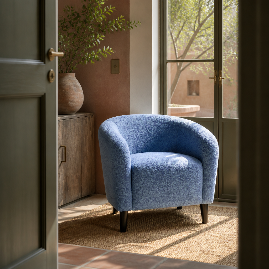 Blue boucle accent chair seen off centre through a doorway in a terracotta apartment