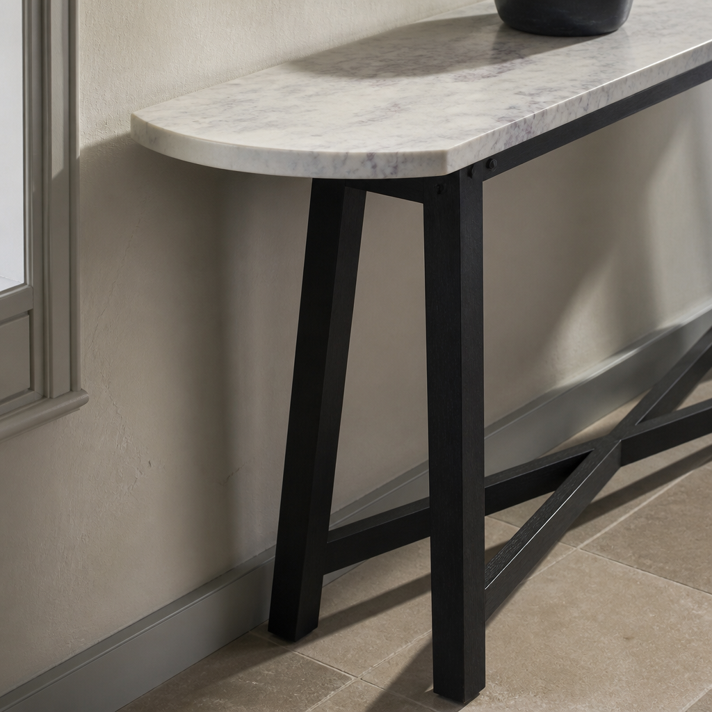 Close view of the honed white marble top meeting the black timber leg