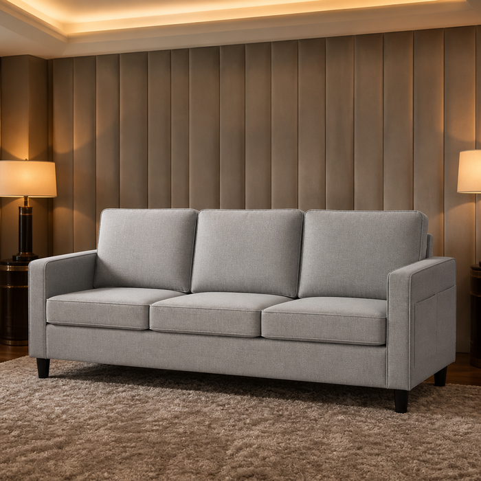 Light grey linen three seat sofa in front of a channelled upholstered wall panel