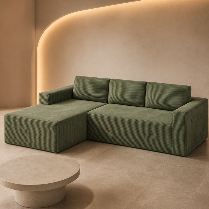 Low sage green corduroy L shaped sectional against a curved plaster wall