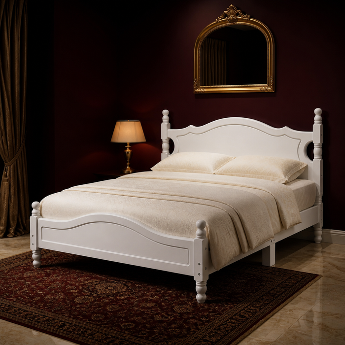 White queen bed frame with a scalloped headboard and turned finial posts, dressed with layered bedding